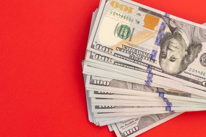 United States or USA dollar currency on a red background. Money for Christmas concept.