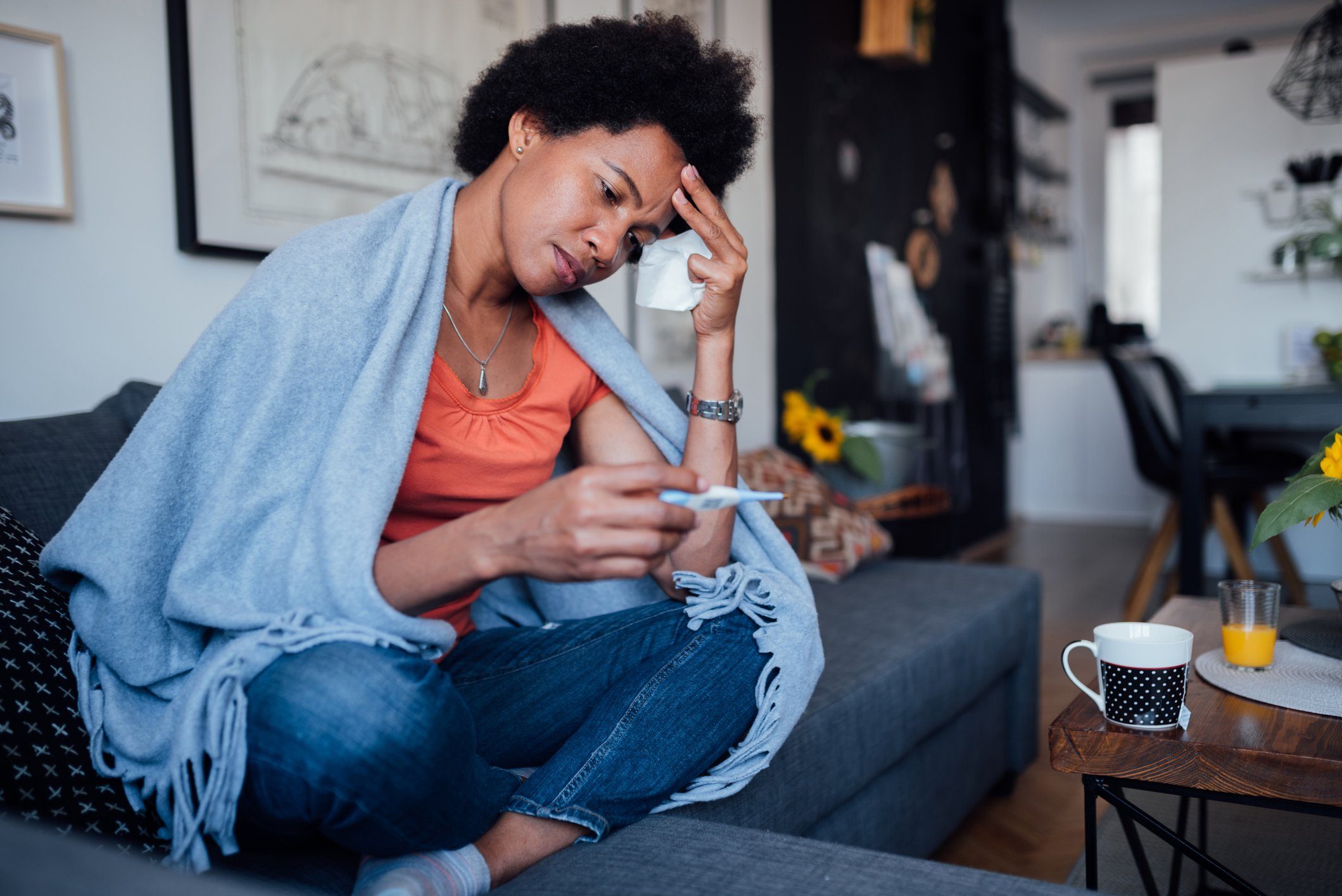woman sick at home with headache and fever