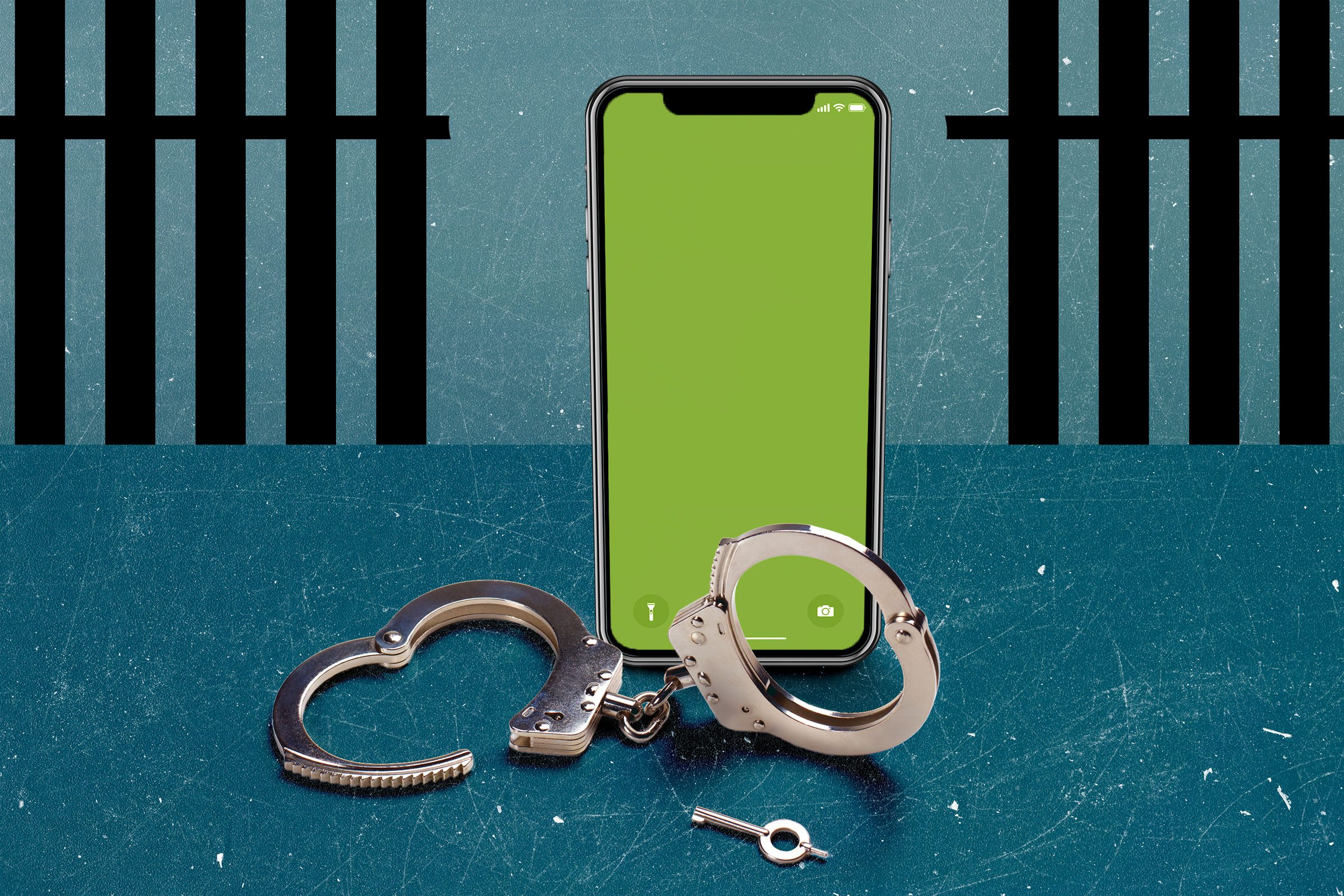 Smartphone stands upright beside open handcuffs and a key on a scratched blue surface, with black prison bars in the background.