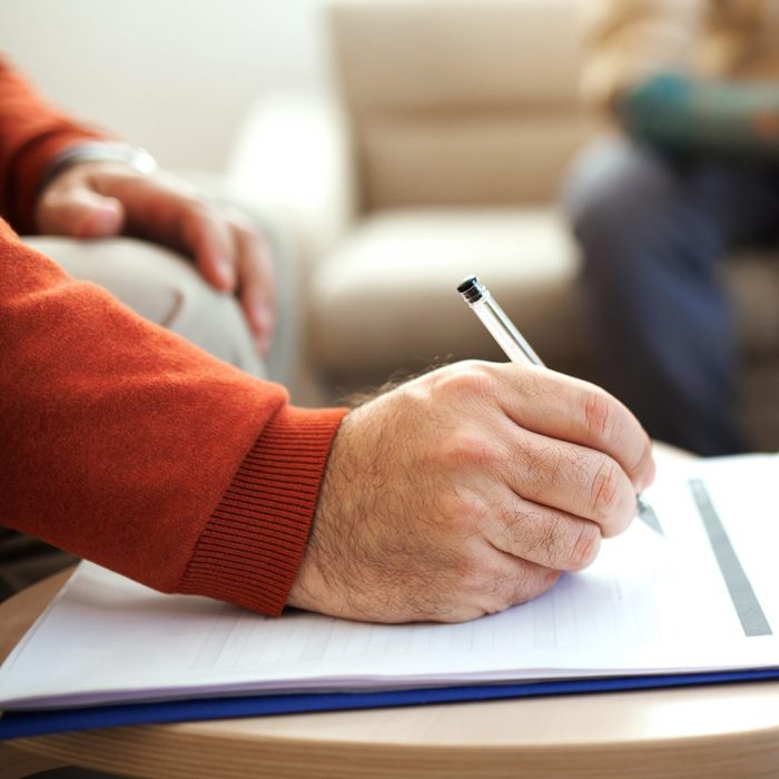 Close up shot of psychologist taking notes on a session